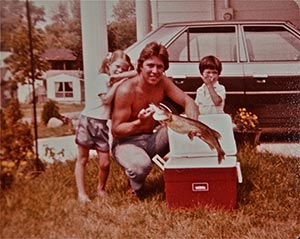 Dad, Audra and Sal showing off a catch, Dodge in the background